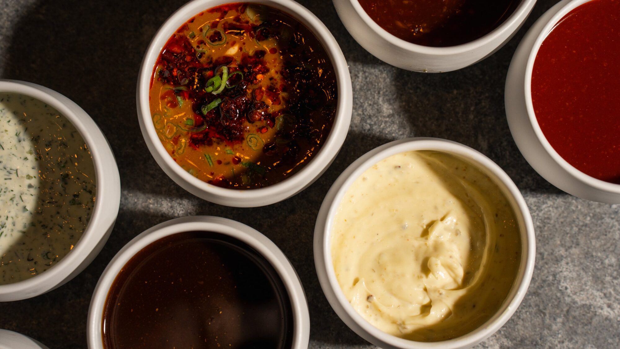 Overhead of Clucks sauces with chili crisp at center