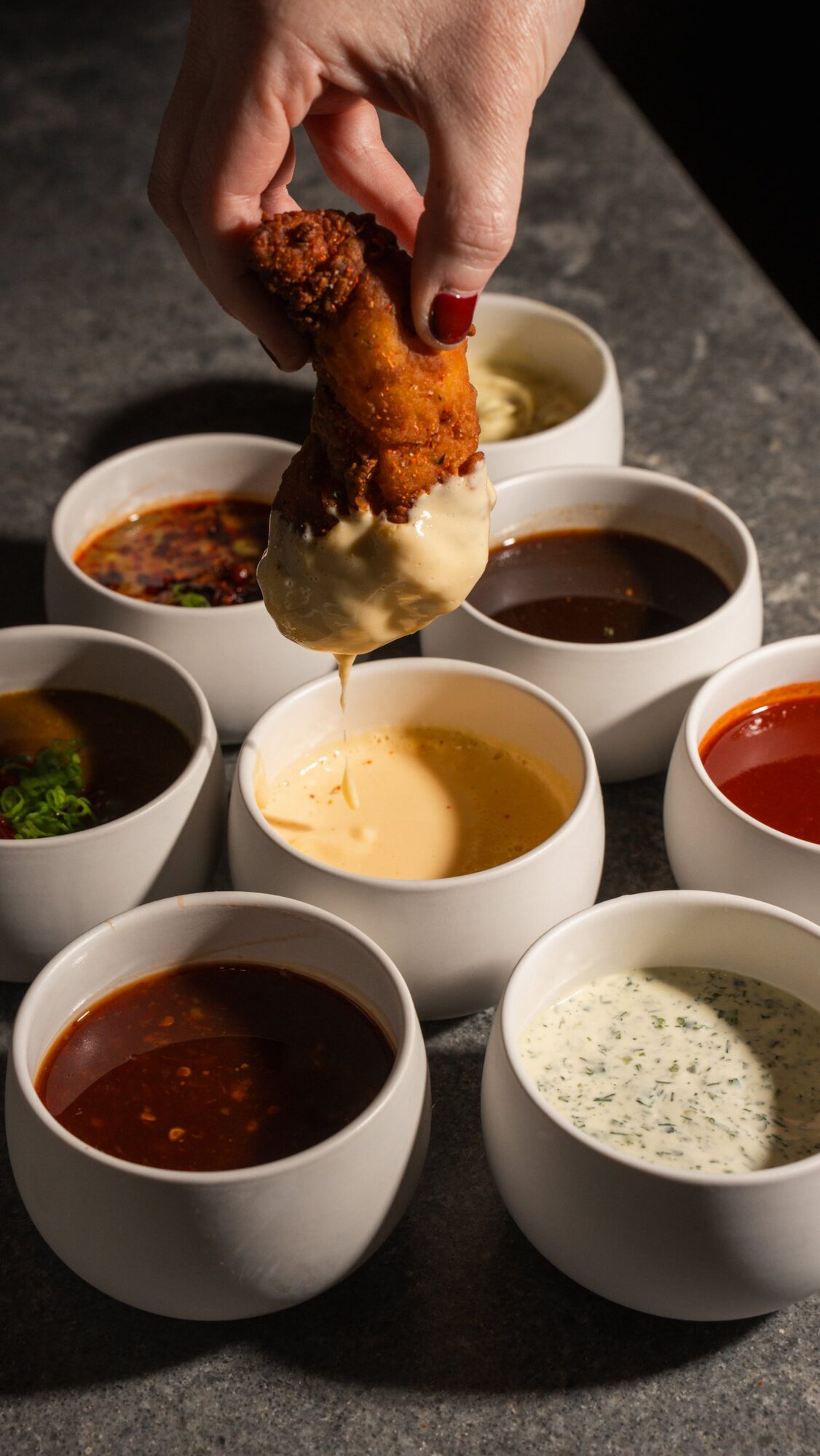 Chicken tender dipped into a cup of sauce