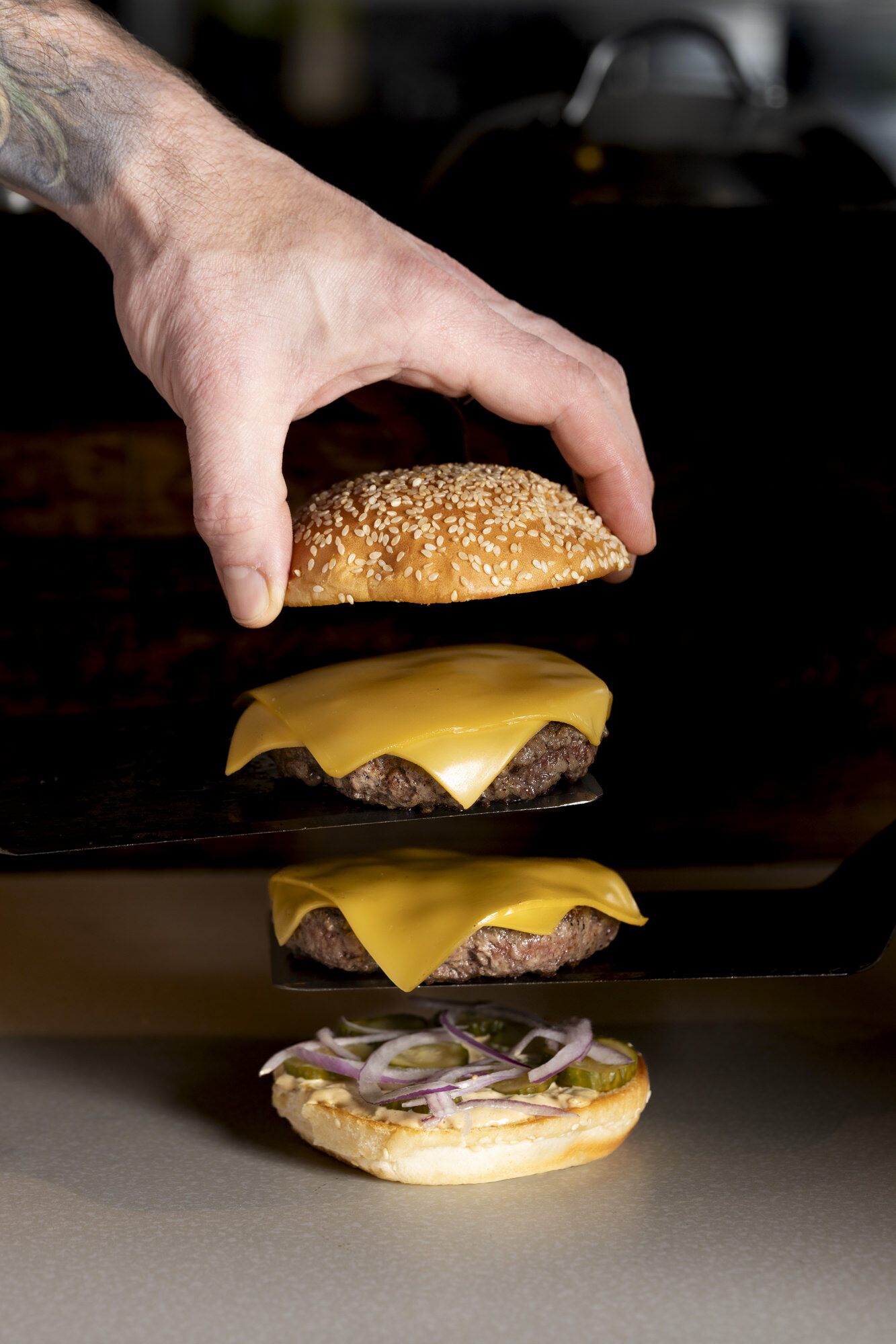 Chef stacking a double cheeseburger