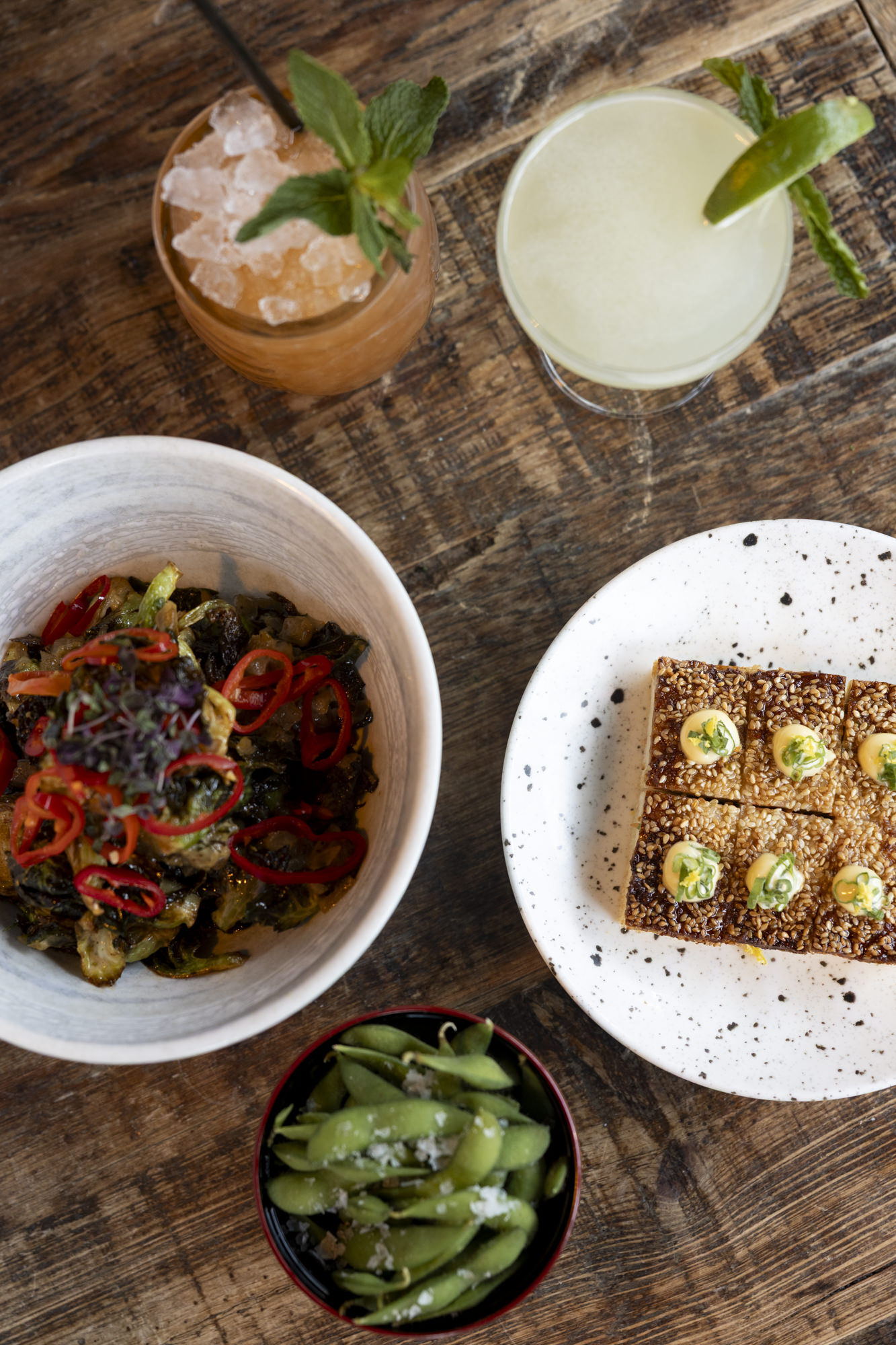 Cocktails, crispy rice, brussels sprouts and edamame from above