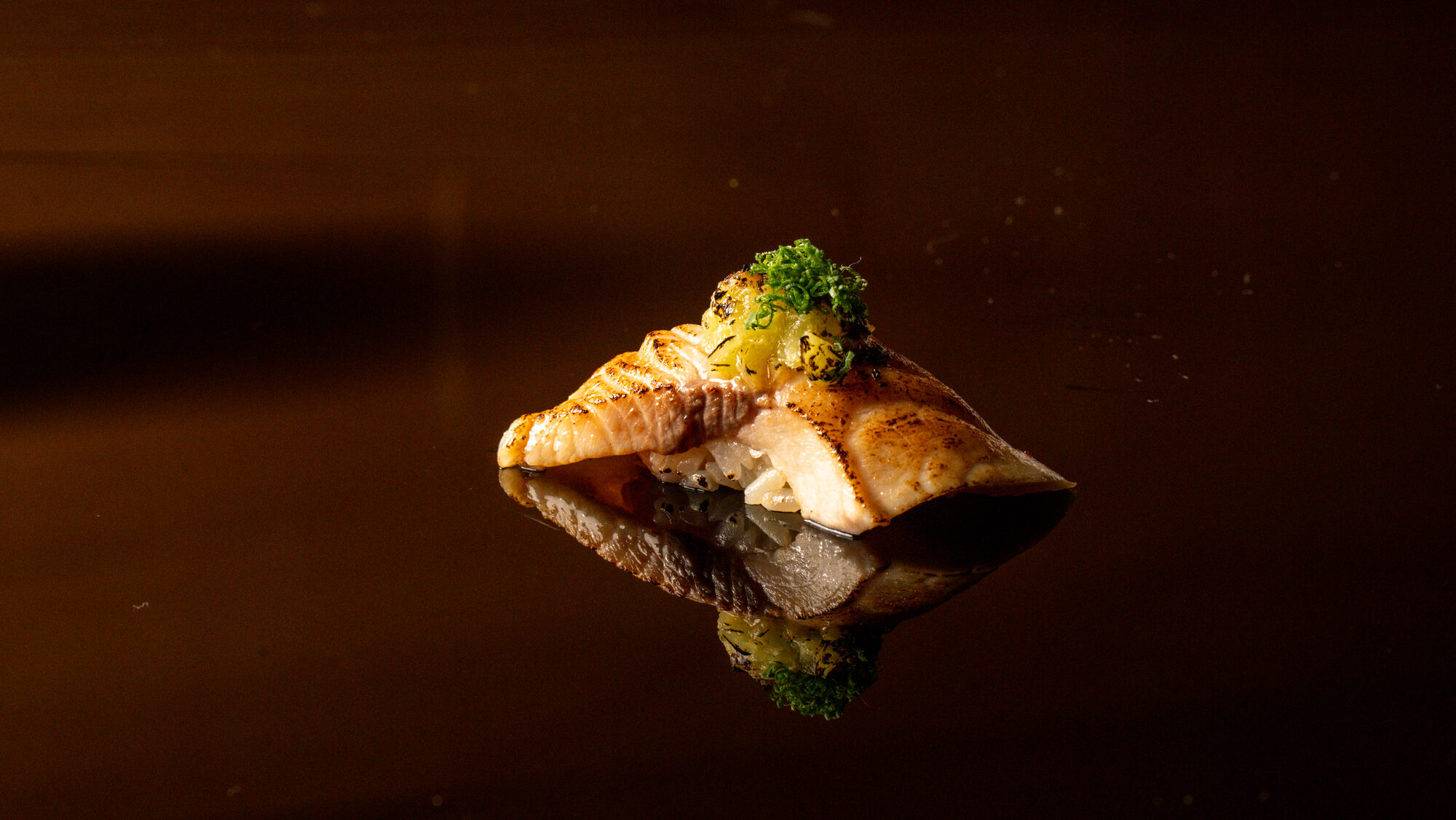 Nigiri glowing on a dark reflective counter